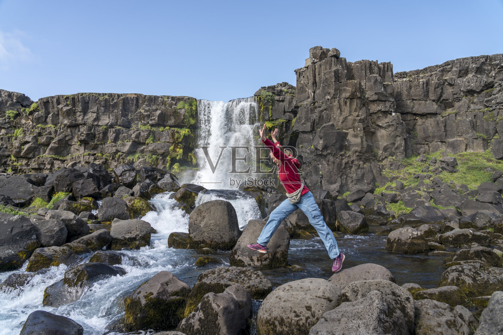 女人们在Oxararfoss瀑布上跳跃照片摄影图片