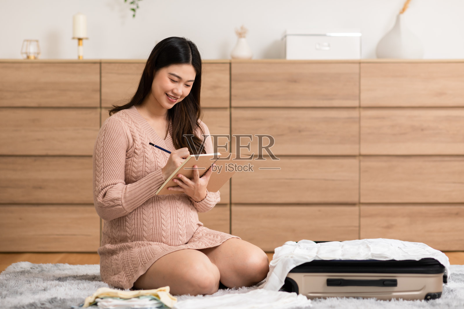 亚洲孕妇在家为宝宝准备尿布和奶瓶。孕妇在收拾婴儿用品，准备去妇产医院。为新生儿概念做准备照片摄影图片