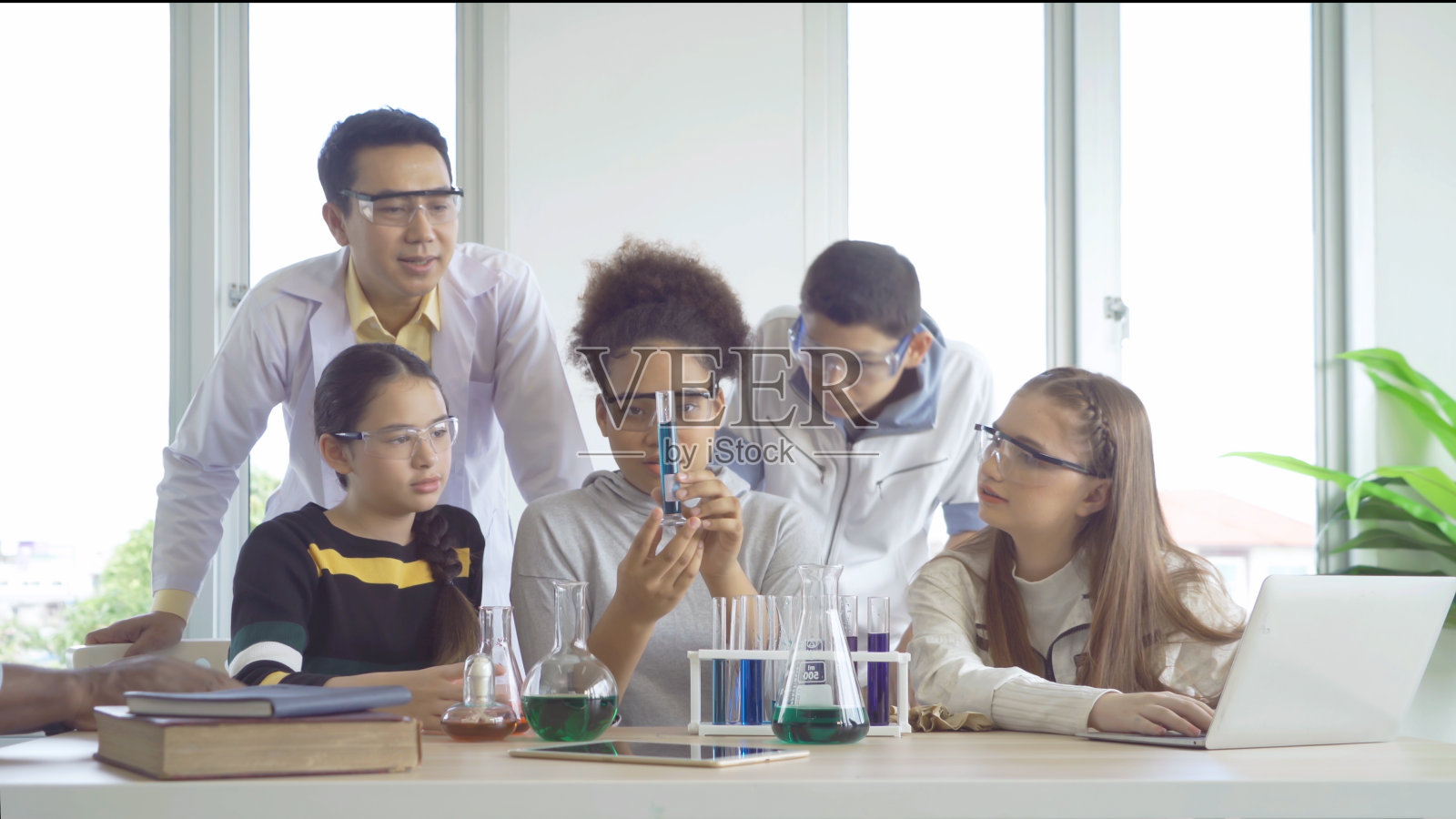 一群多民族的学生、孩子和老师在实验室或学校实验室的试管中学习、医学、化学。实验科学。教育在课堂。人们的生活方式照片摄影图片