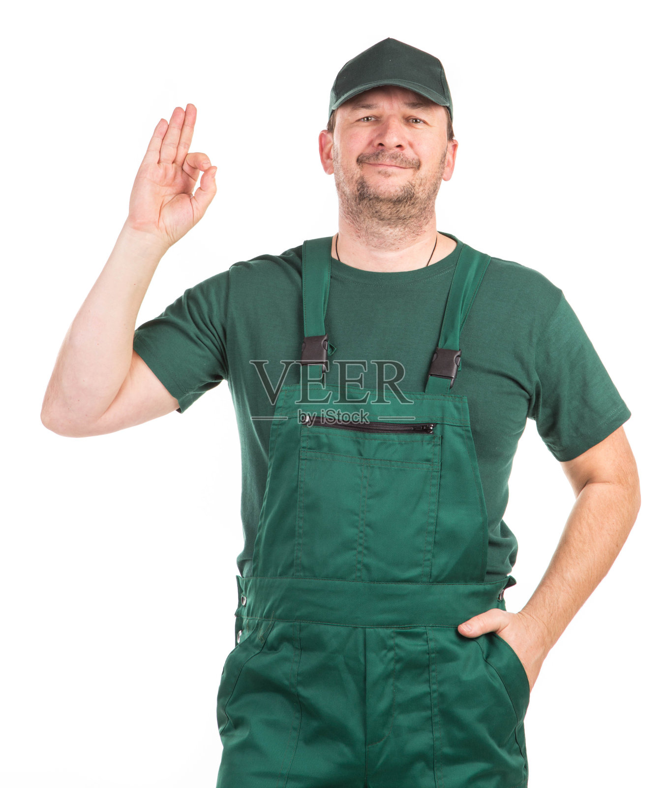 一名身穿绿色连体衣的工人表示“OK”。照片摄影图片