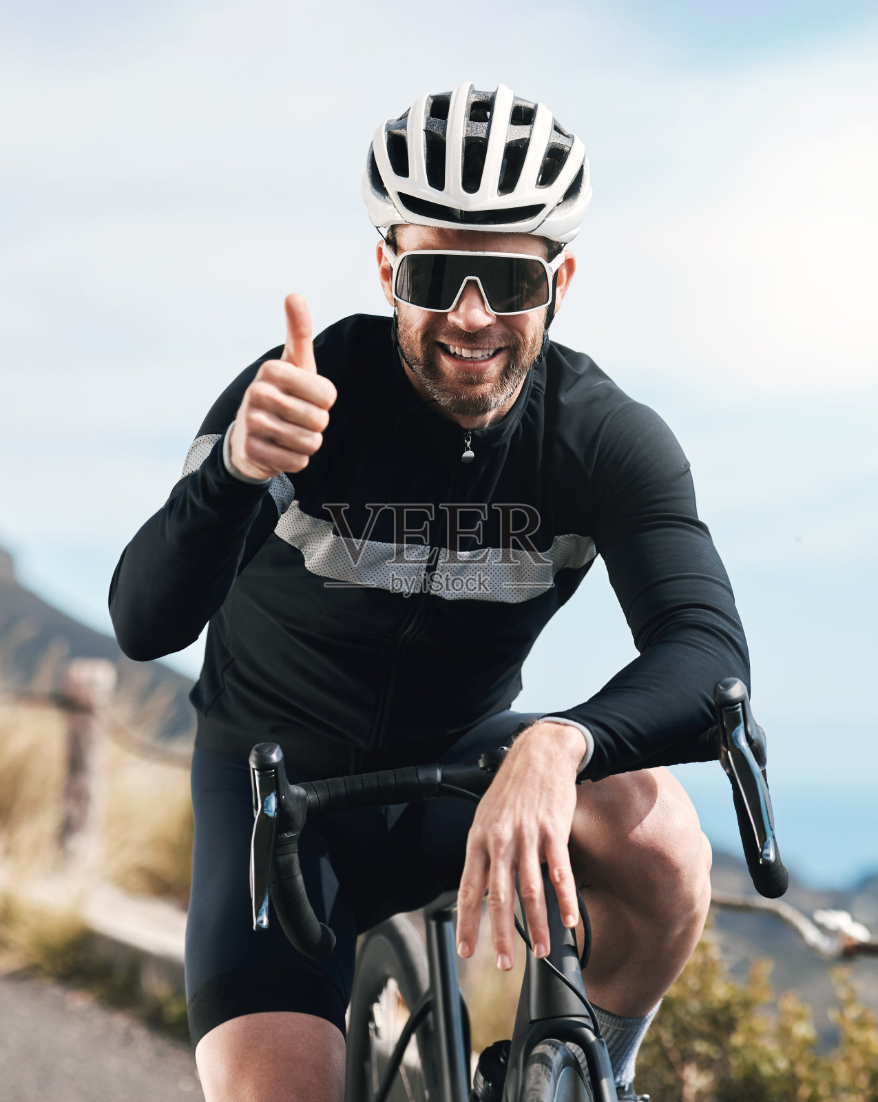 剪裁的镜头，一个英俊的成熟的男人在户外骑车时竖起大拇指照片摄影图片