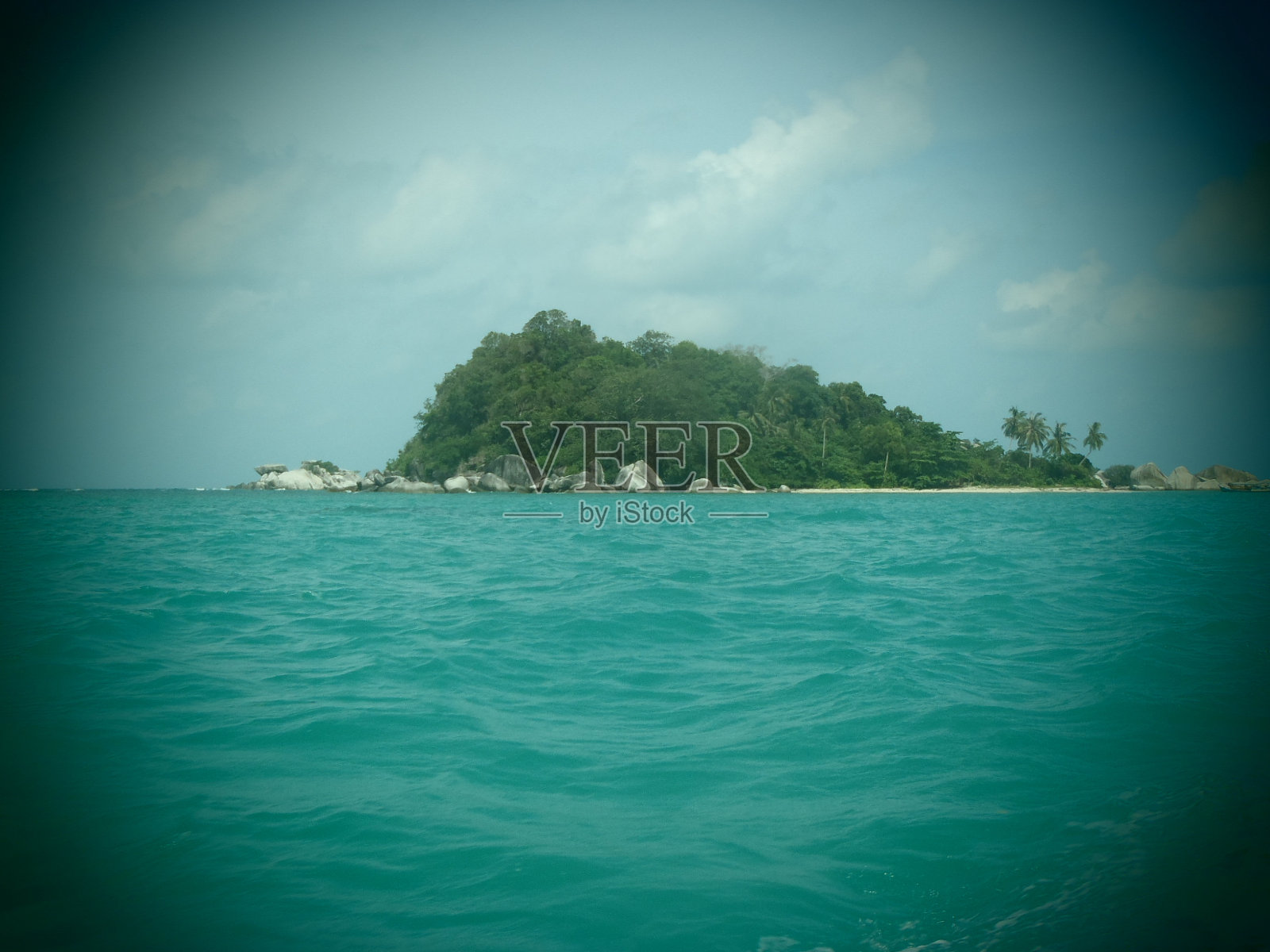 印度尼西亚苏门答腊岛勿里洞岛碧绿大海中间的一个绿色小岛照片摄影图片