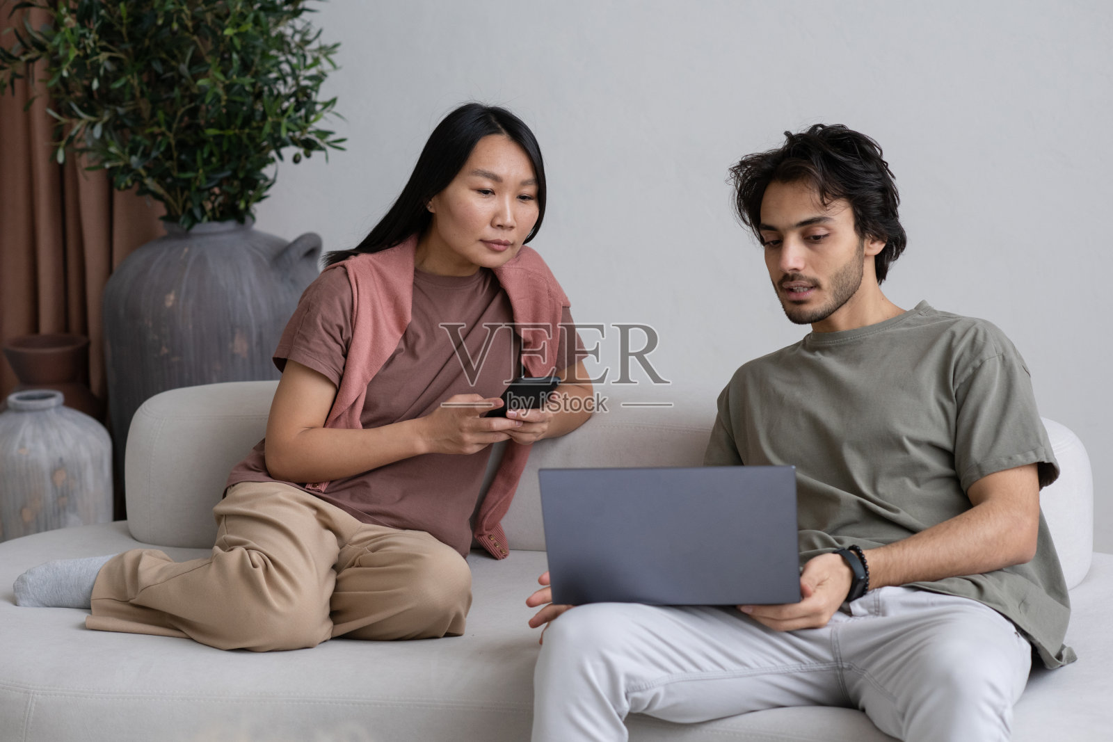 两名年轻员工在演示时盯着笔记本电脑屏幕照片摄影图片