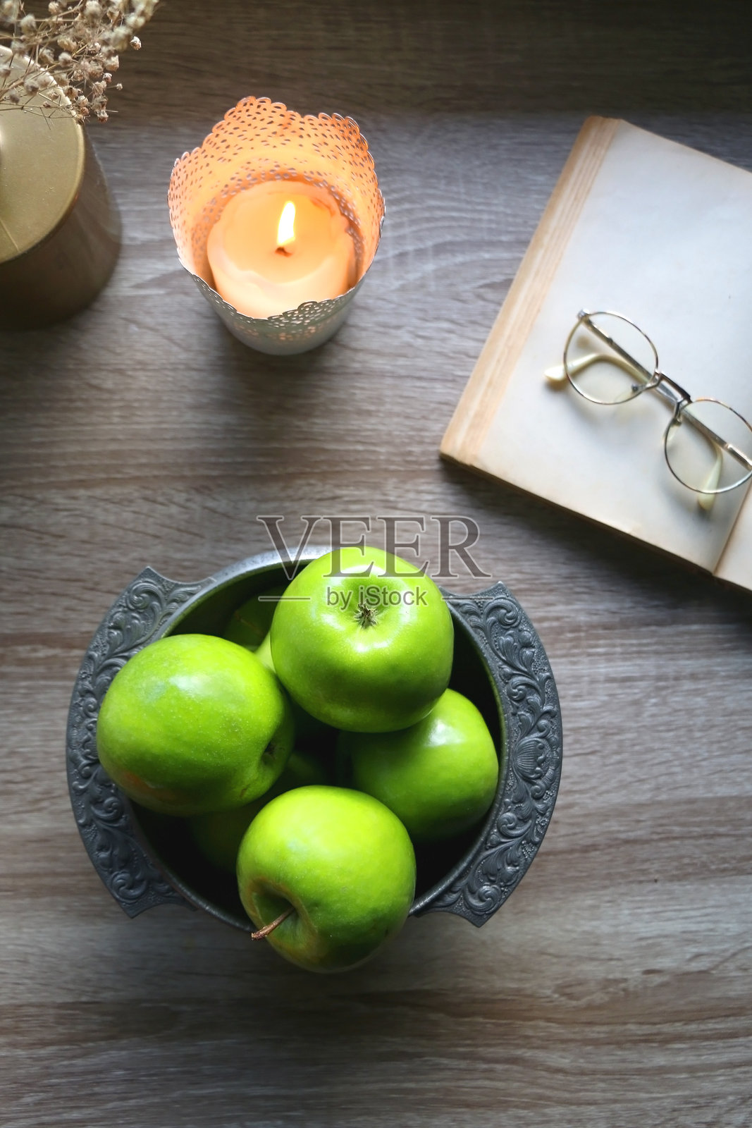 绿苹果，书和蜡烛照片摄影图片