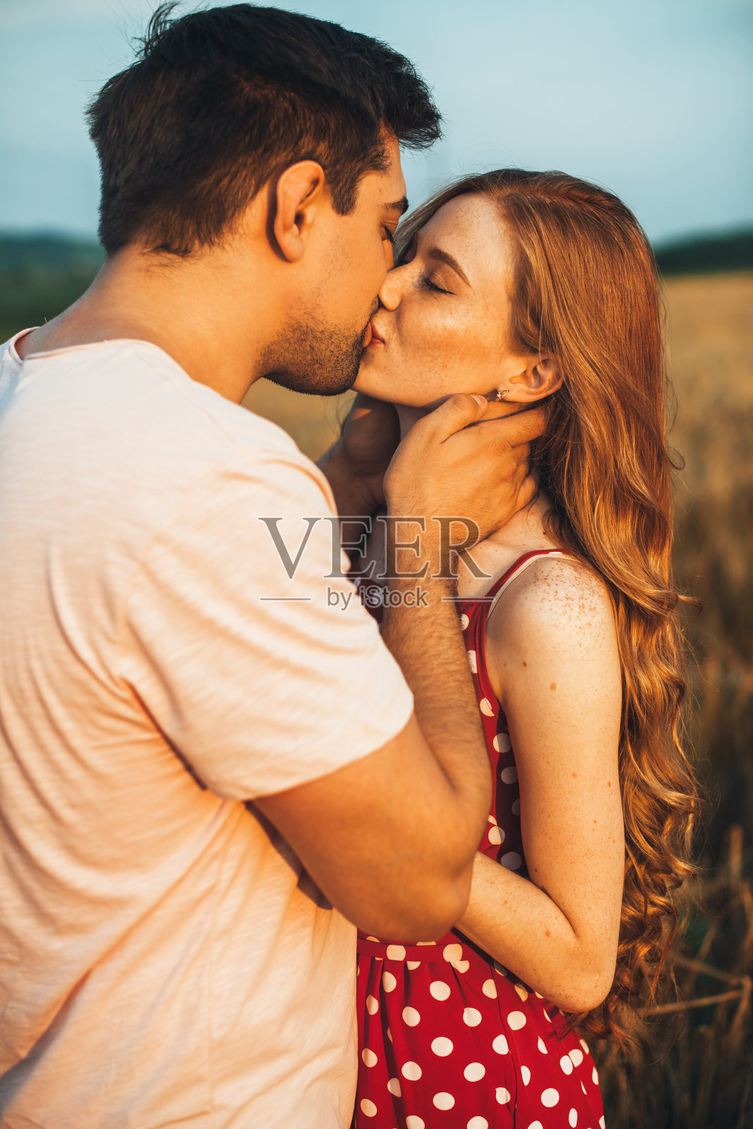 麦田里幸福接吻的情侣的特写。假期。照片摄影图片