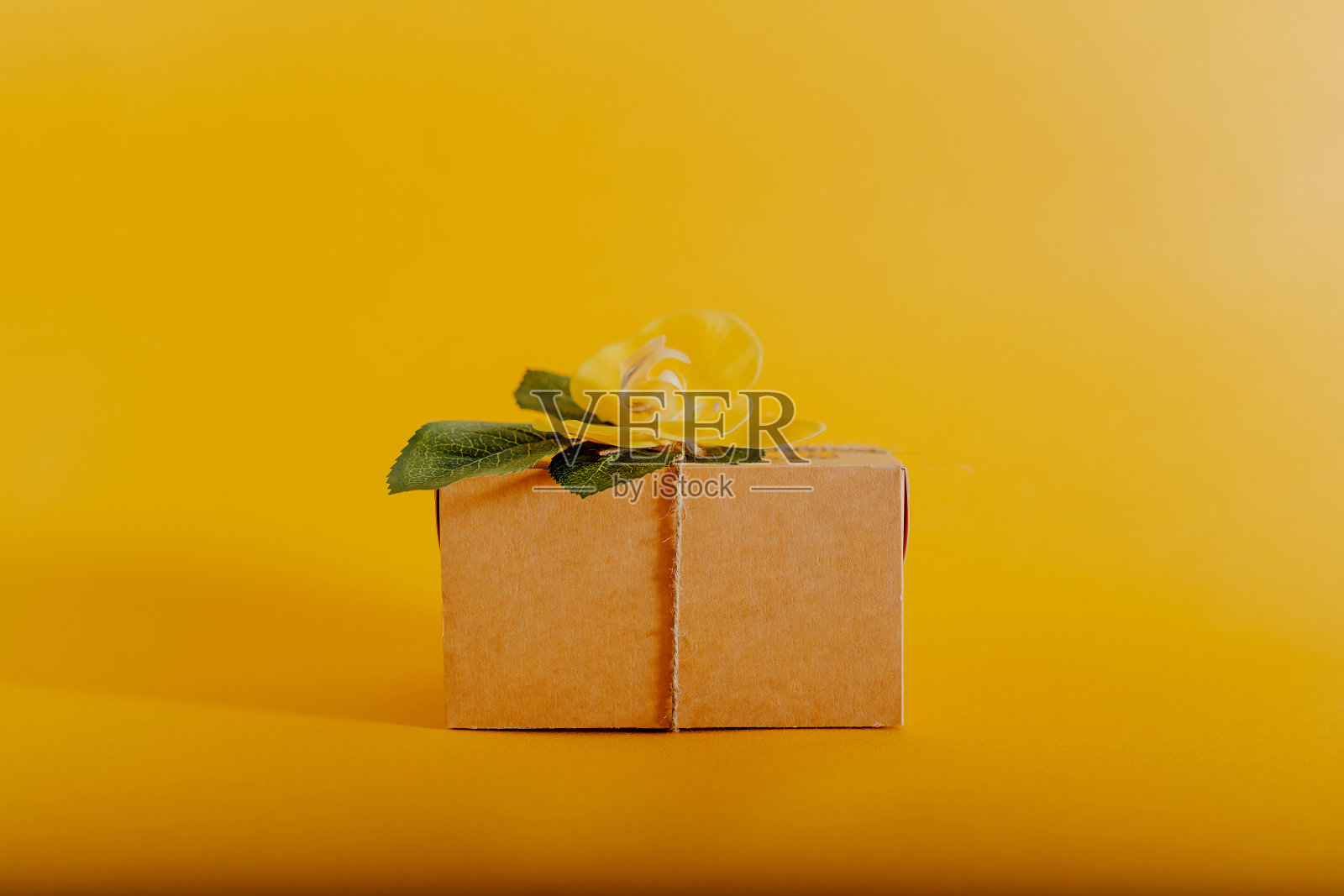 快乐的复活节卡片与礼盒和鲜花在橙色背景。照片摄影图片