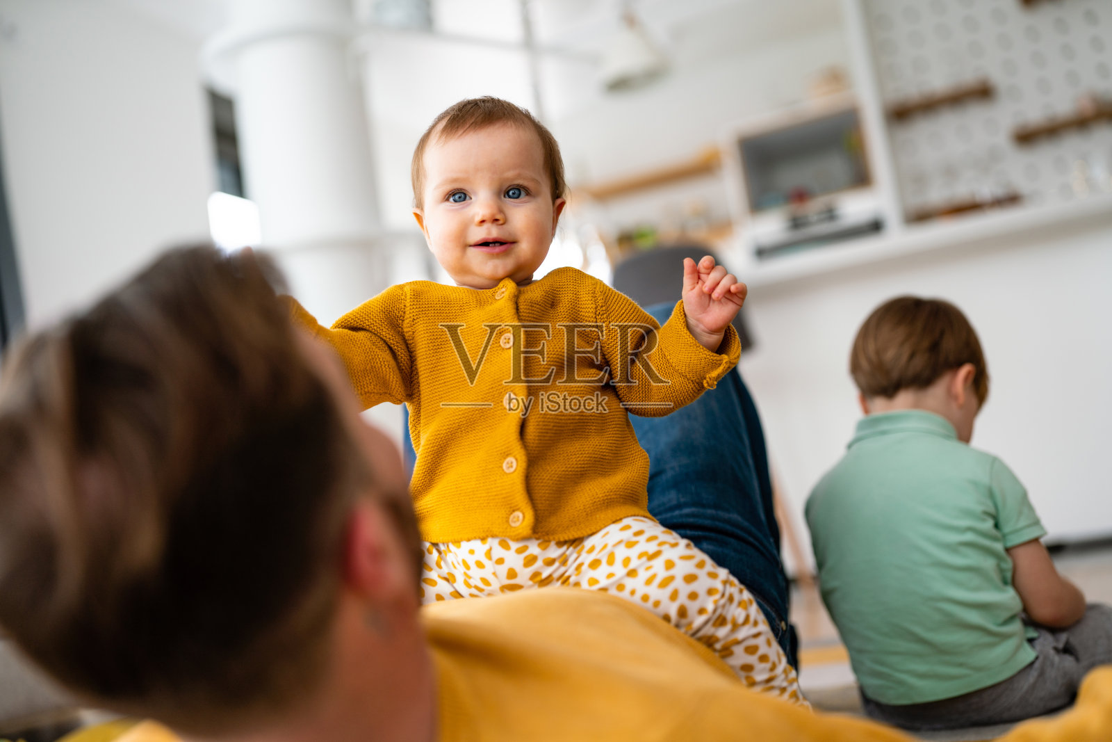 不开心的小男孩感到嫉妒，当他花时间与他的小妹妹在家里照片摄影图片