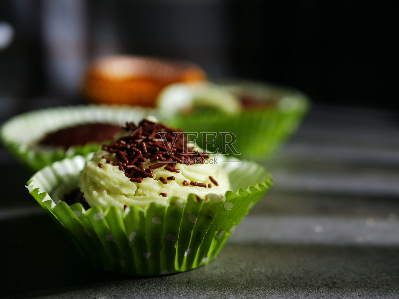 装饰有糖霜和巧克力屑的纸杯蛋糕照片摄影图片