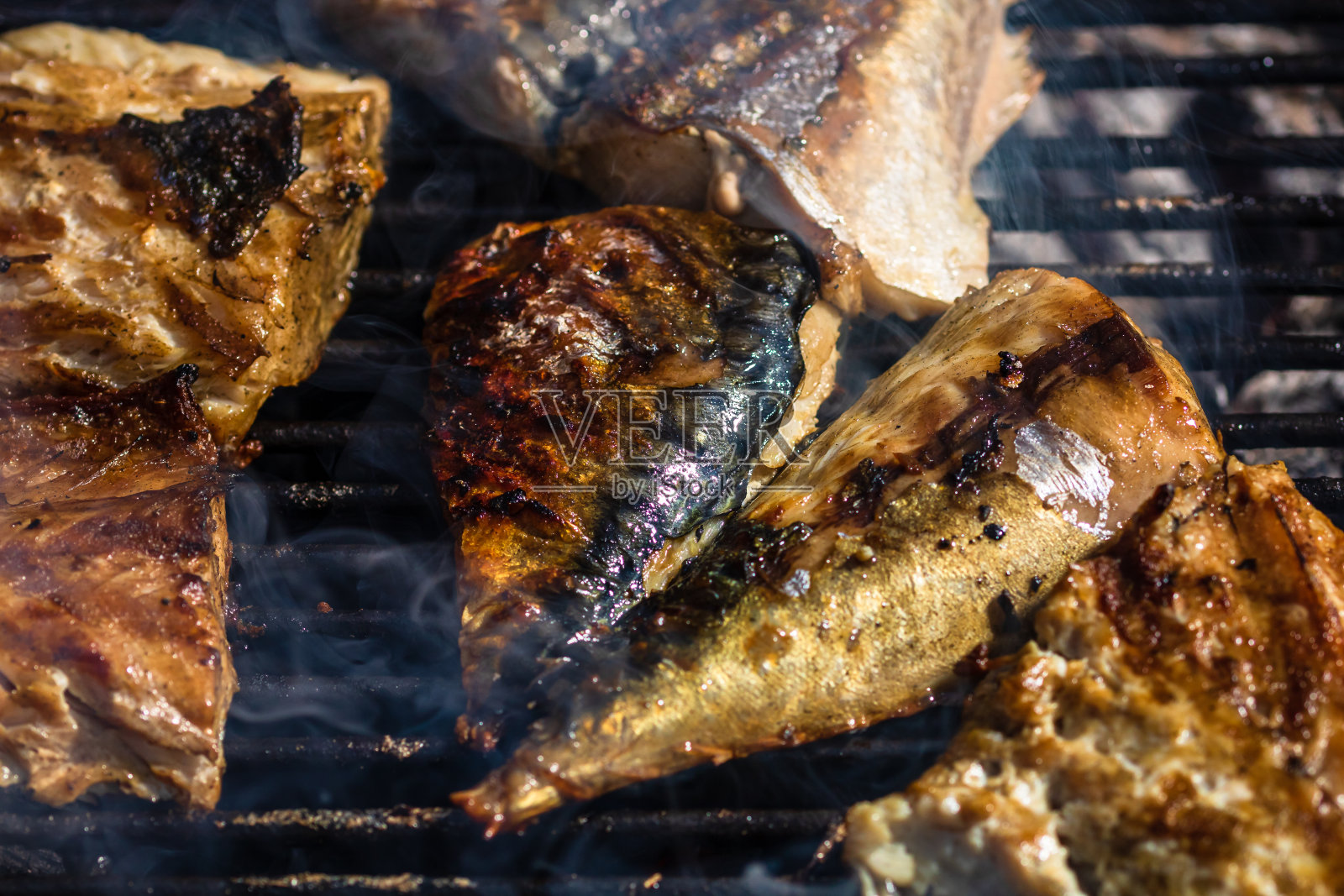 在木炭烧烤架上烤制烟熏鲭鱼。照片摄影图片