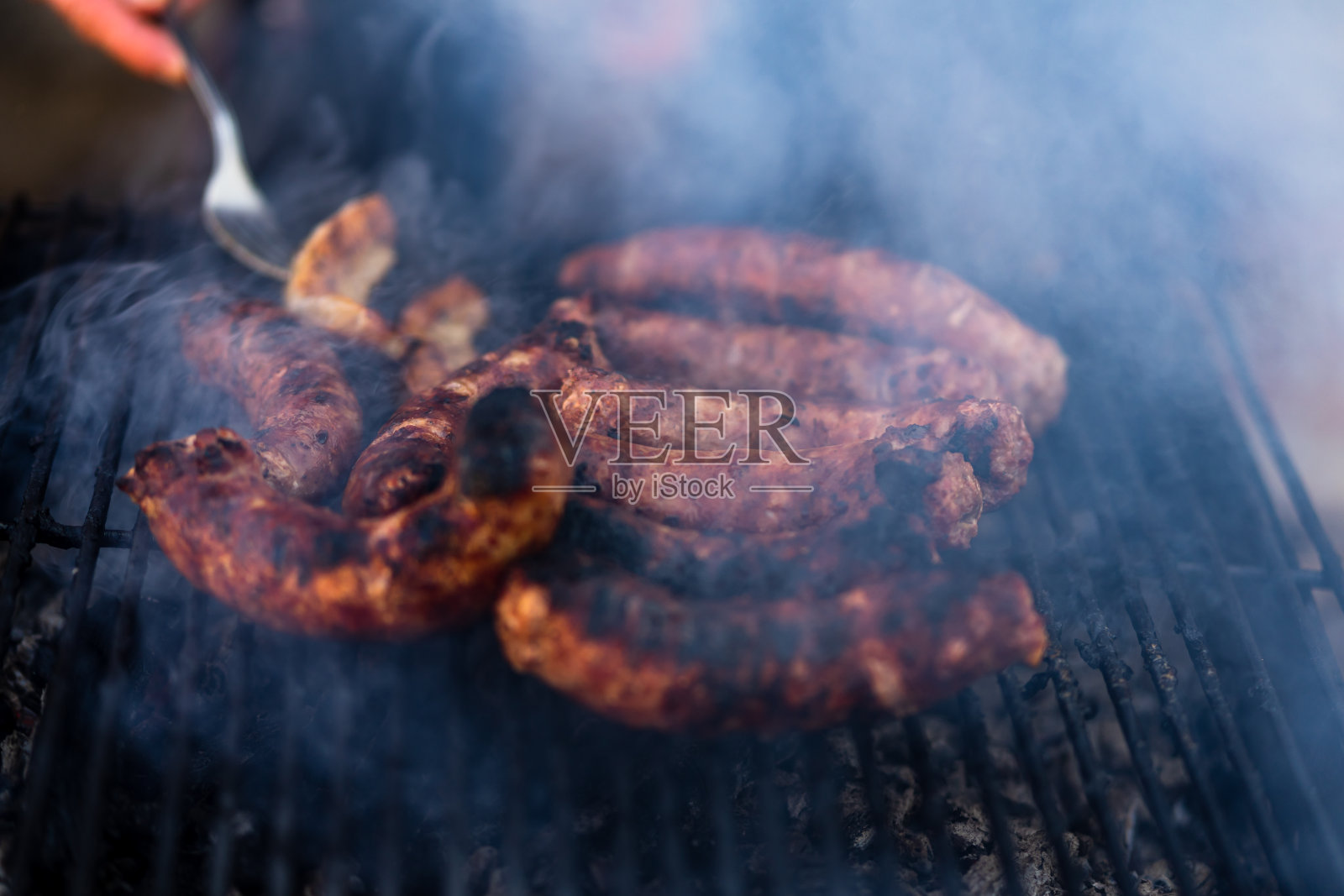 在烧烤架上烤香肠。木炭烤架上美味的香肠照片摄影图片