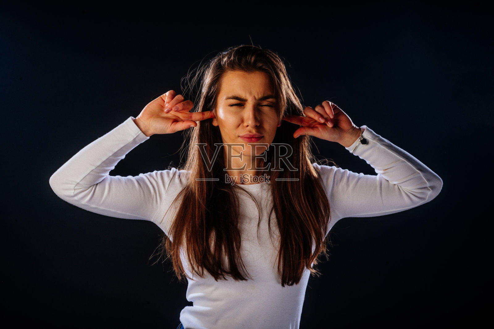 20多岁的女孩捂着耳朵，忍受着巨大的噪音，不开心的女性感到痛苦照片摄影图片