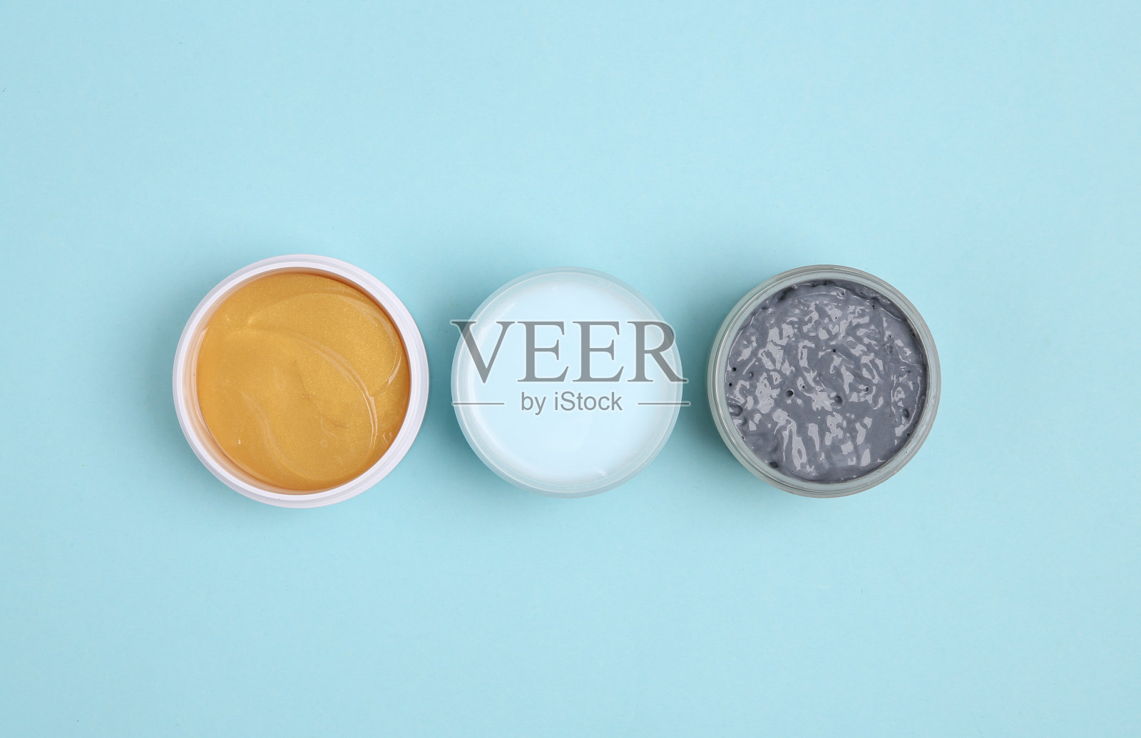 一罐面霜，黑色黏土和蓝色背景的补丁。美容产品,化妆品。俯视图照片摄影图片