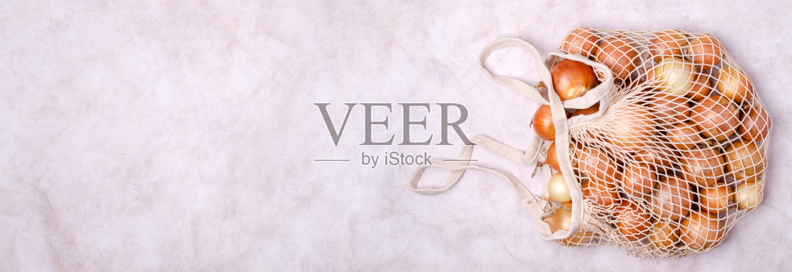 针织袋装的新鲜黄洋葱照片摄影图片