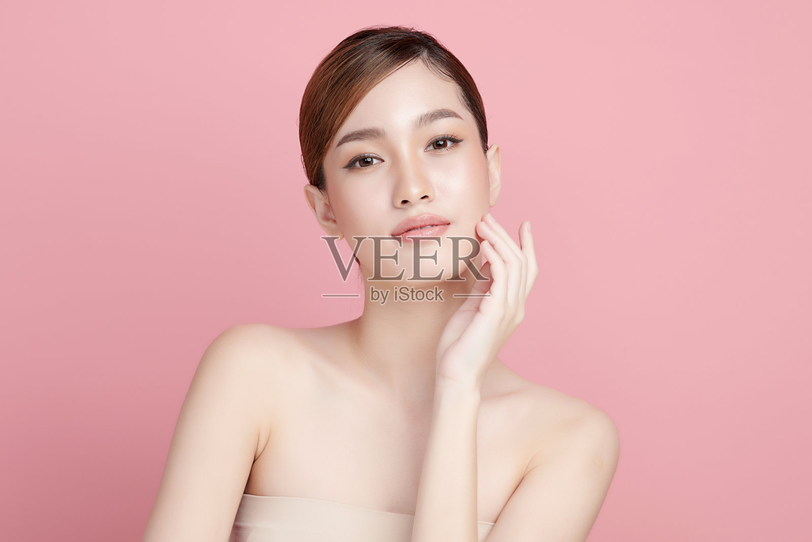 美丽年轻的亚洲女性与清洁新鲜的皮肤粉红色背景，面部护理，面部治疗，美容，美容和水疗，亚洲女性肖像。照片摄影图片