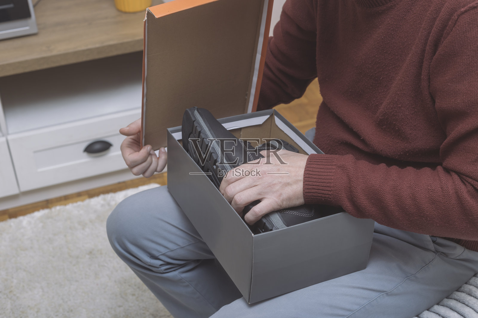 男人打开箱子，试穿新鞋子照片摄影图片