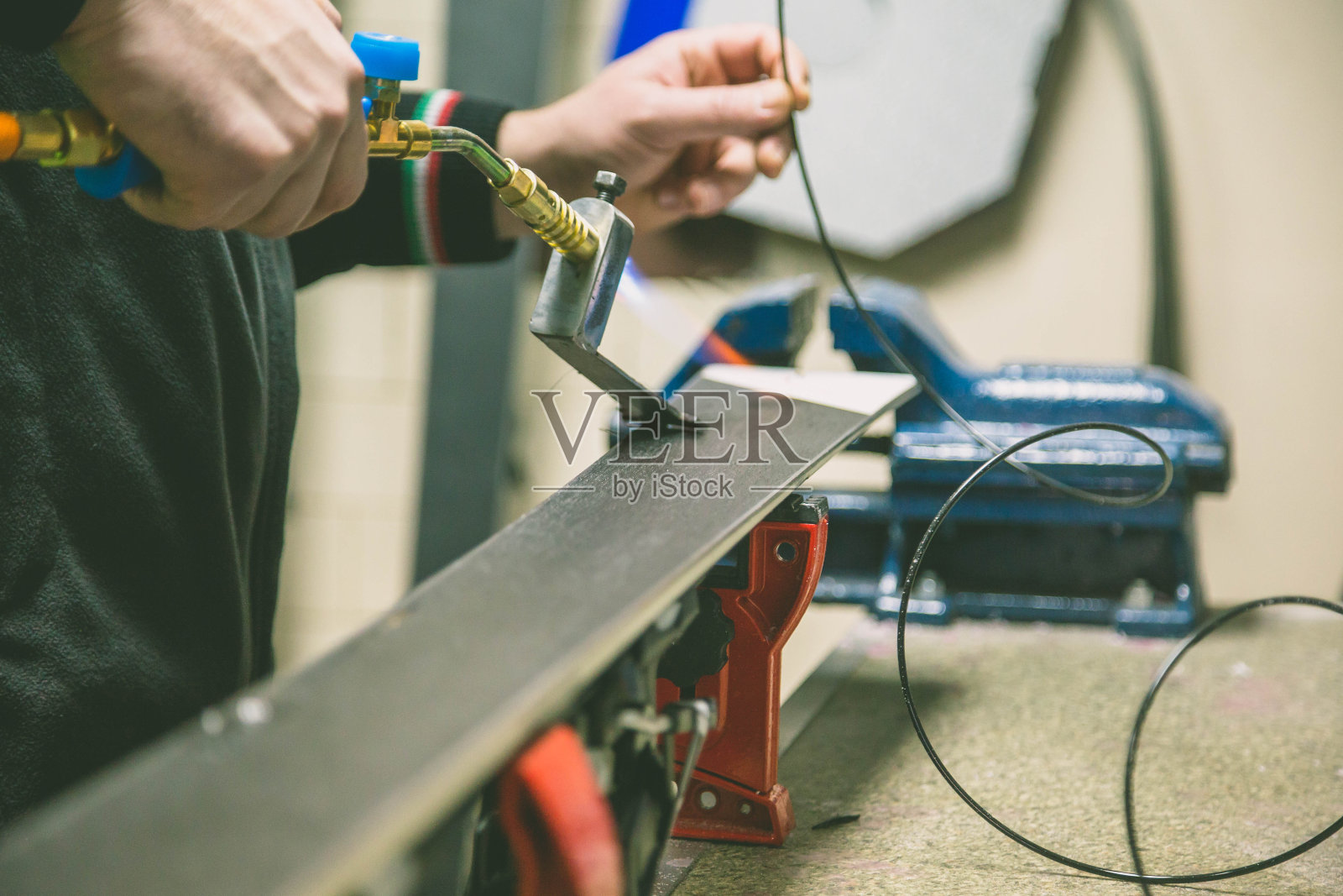 用单独的工具磨山滑雪板的边缘照片摄影图片