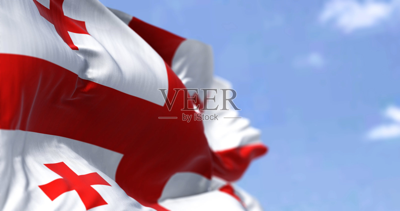 在一个晴朗的日子里，格鲁吉亚国旗在风中飘扬照片摄影图片