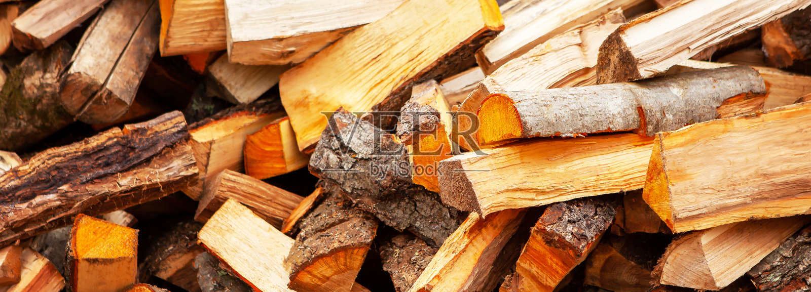 背景以劈柴的形式为房子供暖，随意堆放。特写镜头。照片摄影图片