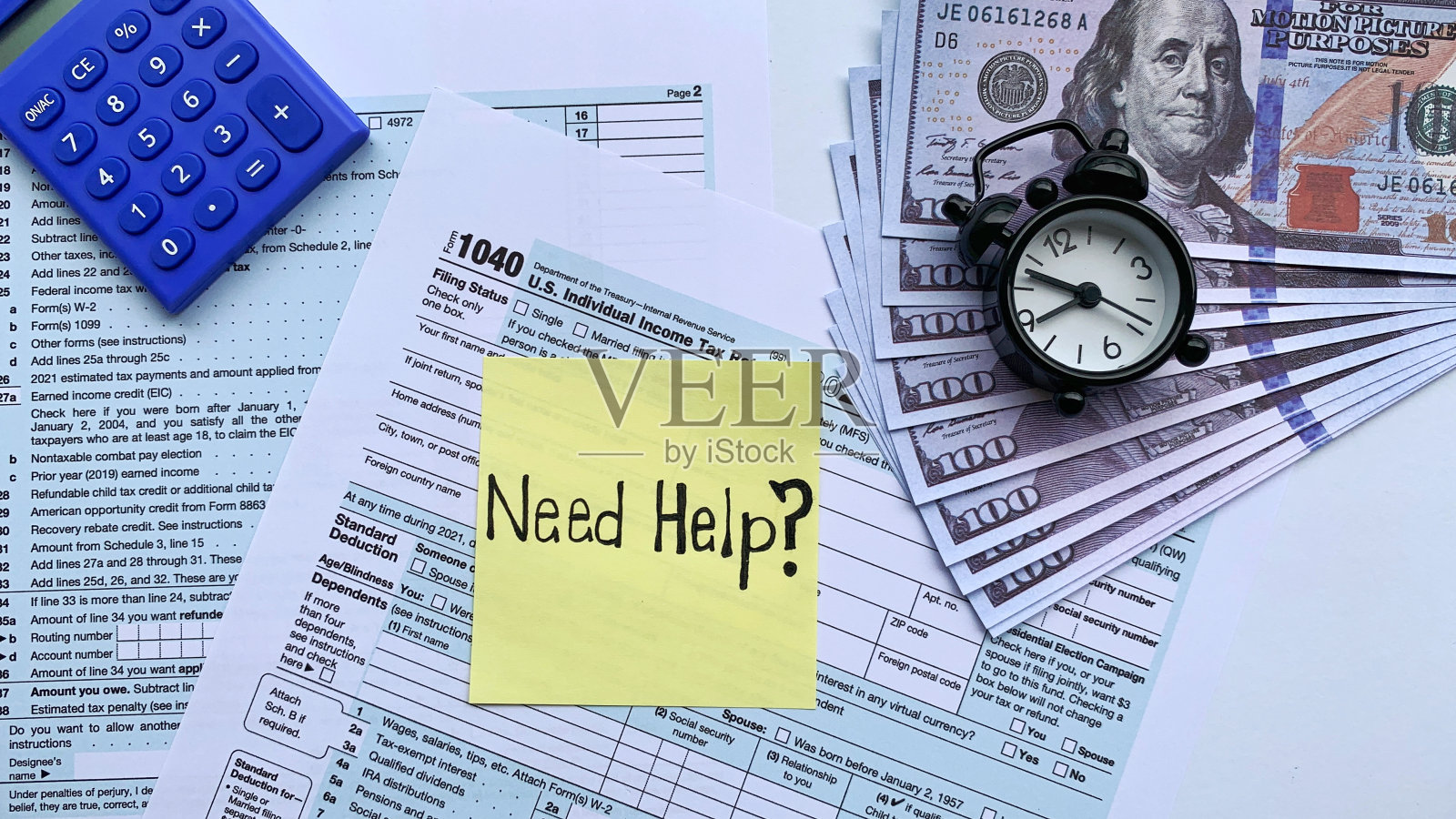 黄色记事本上的文本顶部视图-需要帮助。与税务表格，银行票据，闹钟和蓝色计算器背景。照片摄影图片