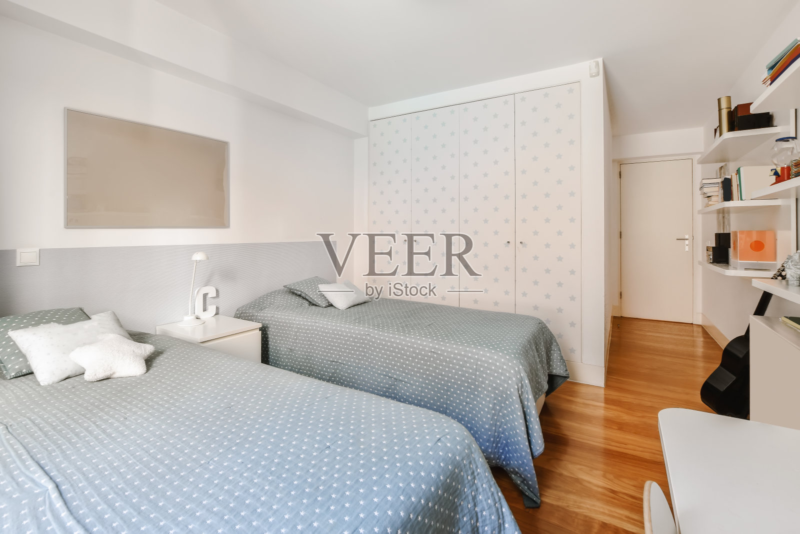 一间迷人的卧室，有两张床，上面盖着一条灰色的毯子照片摄影图片