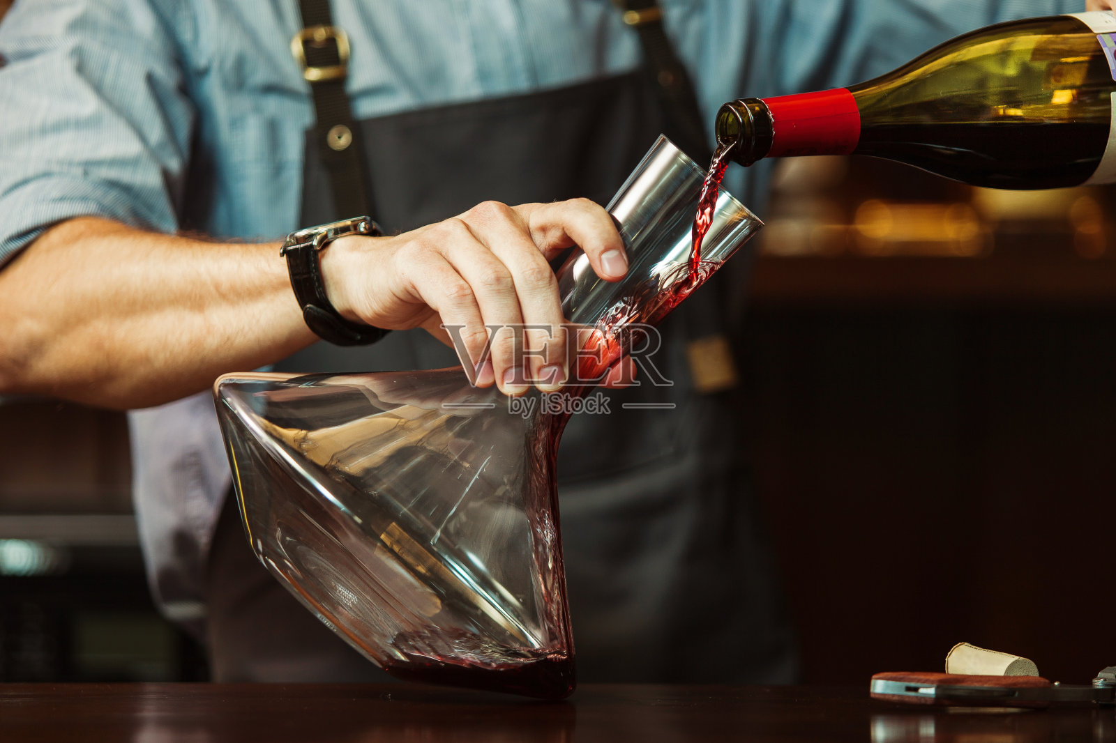 侍酒师将红酒倒入玻璃瓶，使其呈现出完美的颜色照片摄影图片