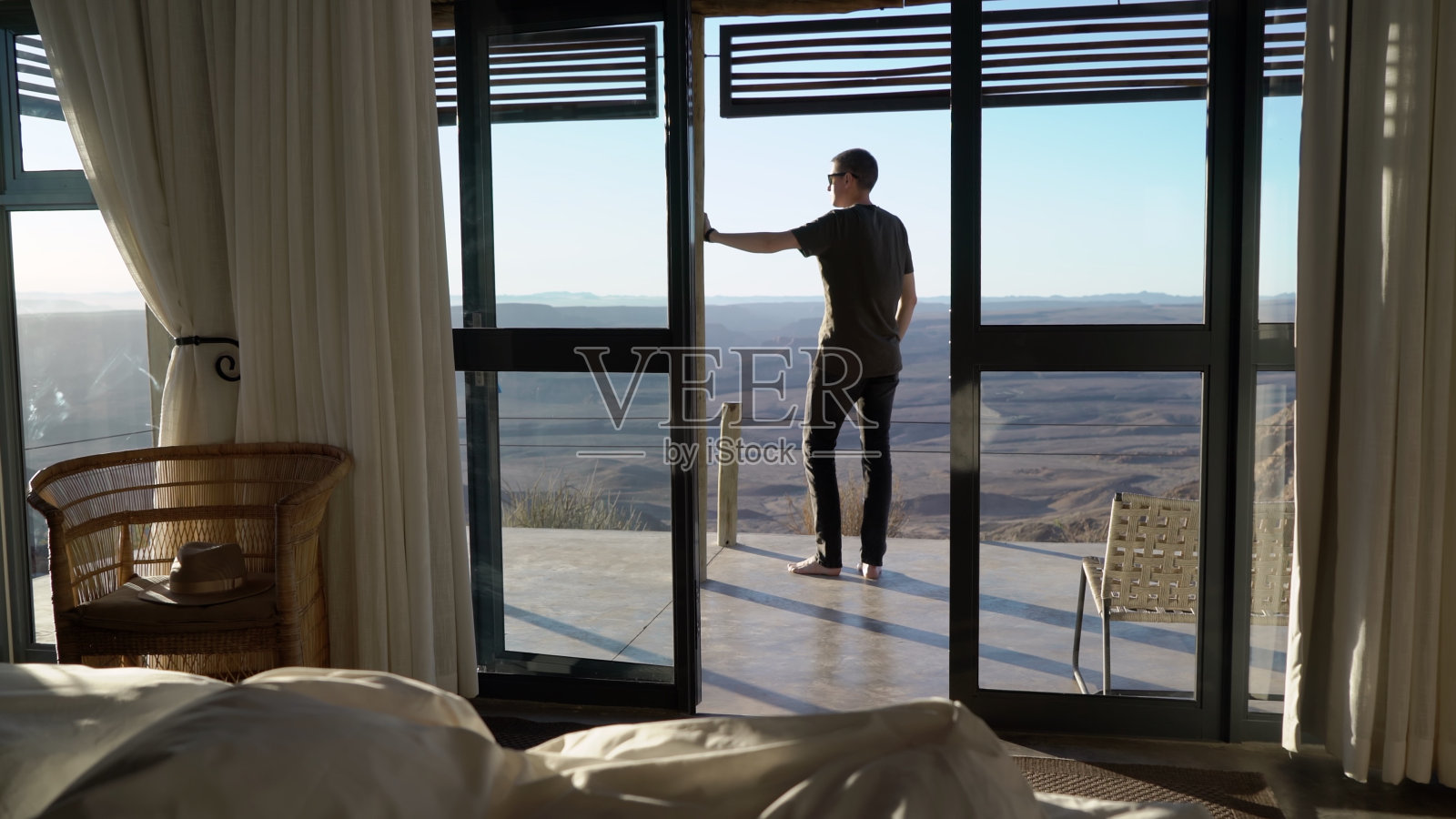 男子站在露台上，欣赏纳米比亚鱼河峡谷的景色照片摄影图片