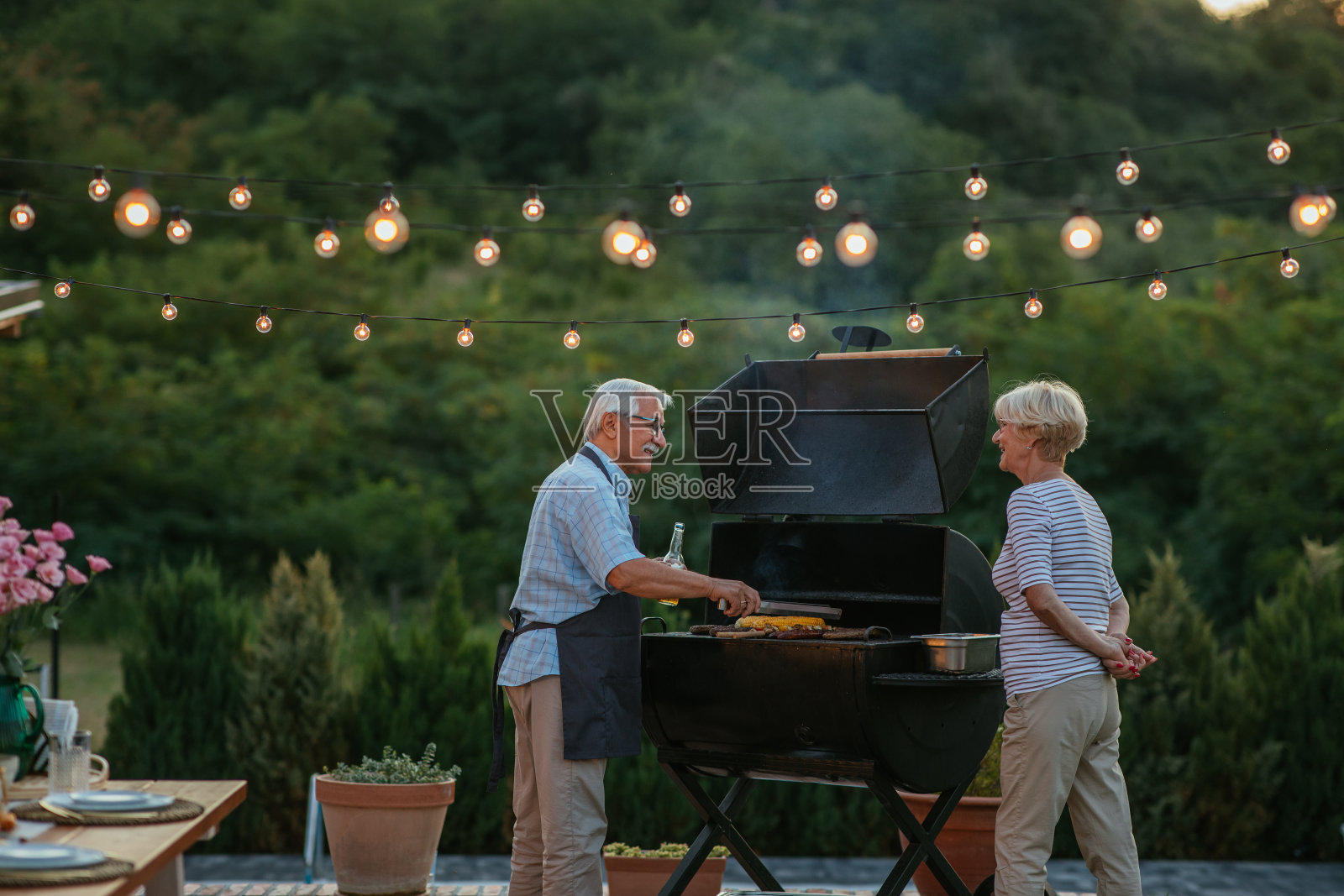 老夫妇在后院享受烤肉照片摄影图片