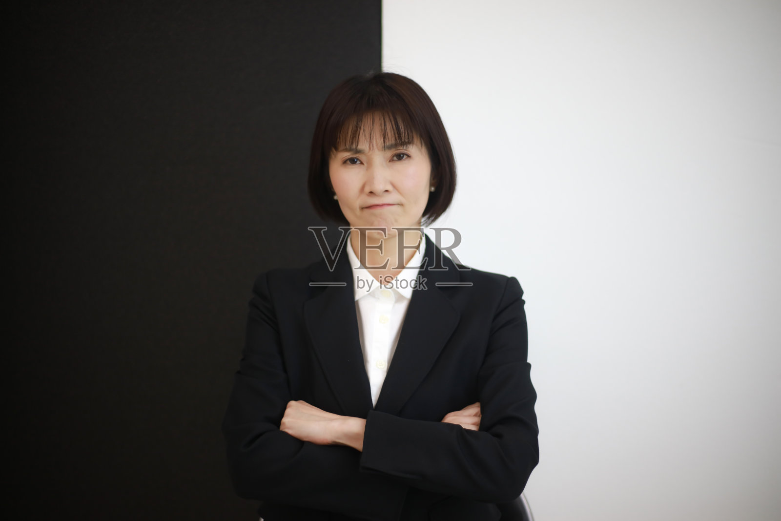 女员工站在一堵黑白墙前照片摄影图片