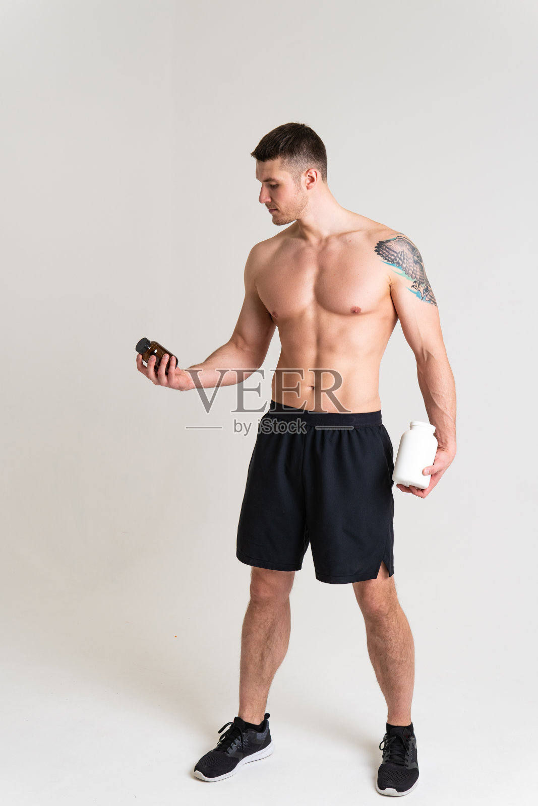 健身蛋白瓶白色的白色背景健美粉强烈的高痛伤伤，抽筋脊柱白色背景肌肉握持。捧红护身，病患诱人照片摄影图片