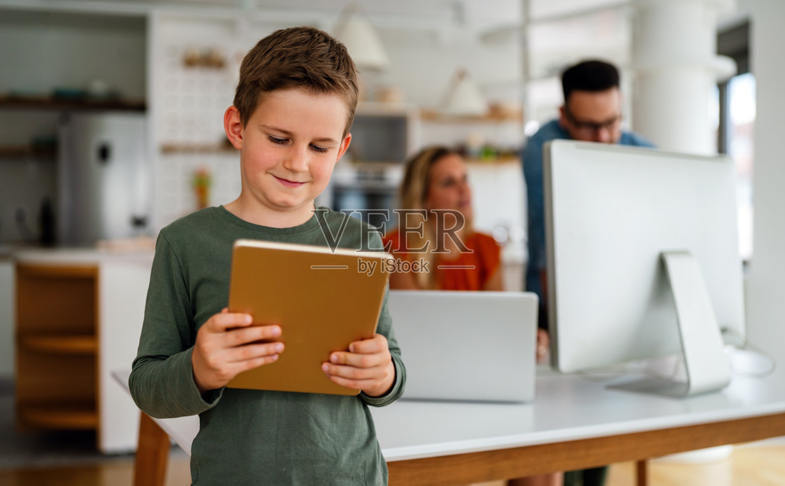 家庭教育社会远程教育在线教育概念。快乐的男孩在家用平板电脑。照片摄影图片