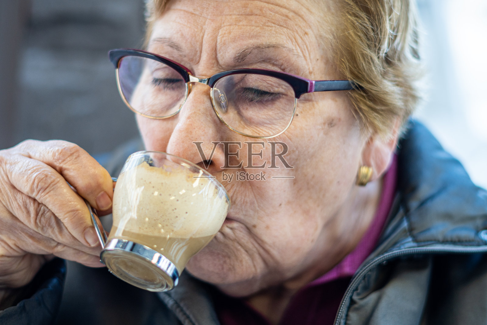 老年妇女喝牛奶咖啡的特写照片摄影图片