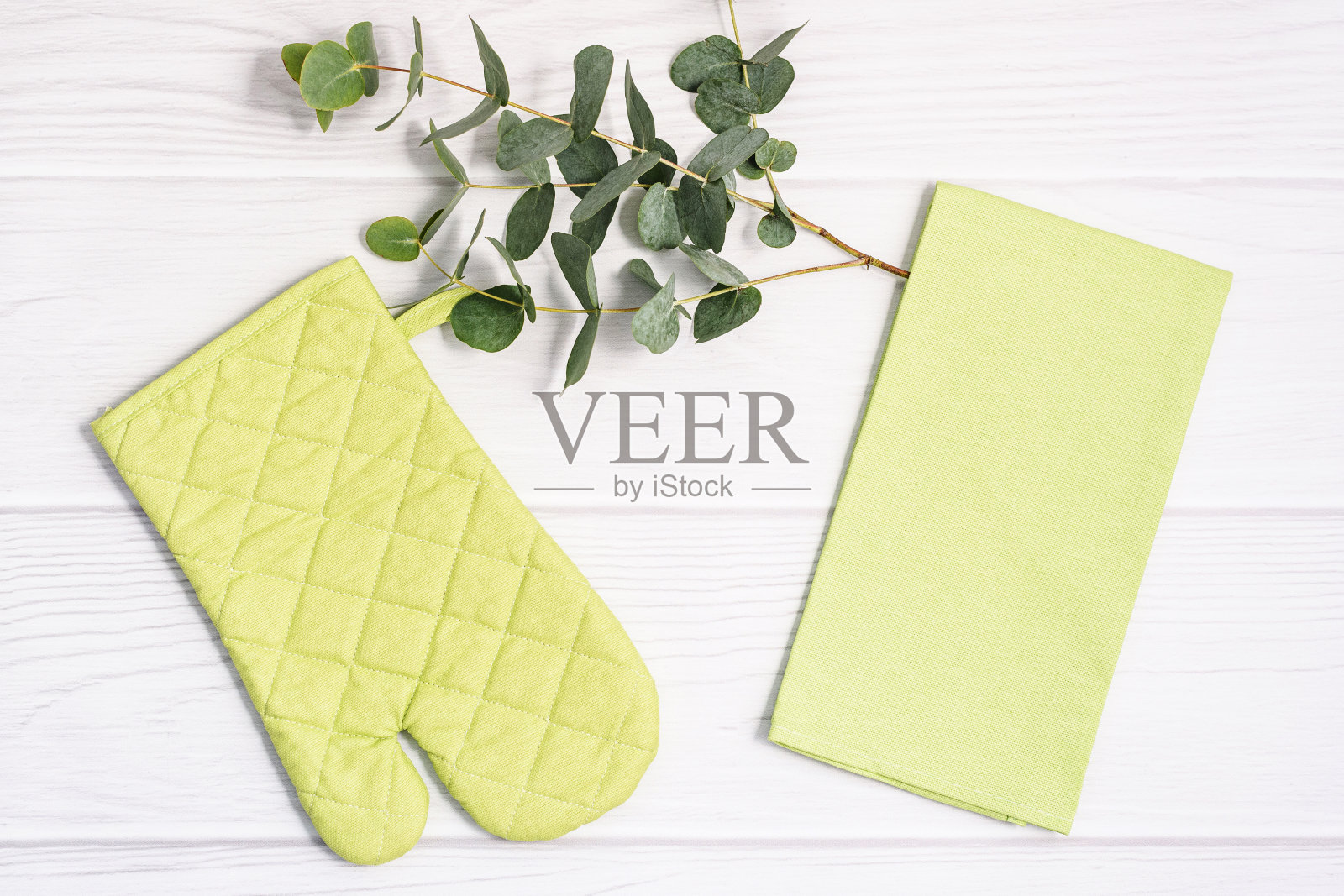 烤箱手套壶托和茶毛巾在白色木制背景。照片摄影图片