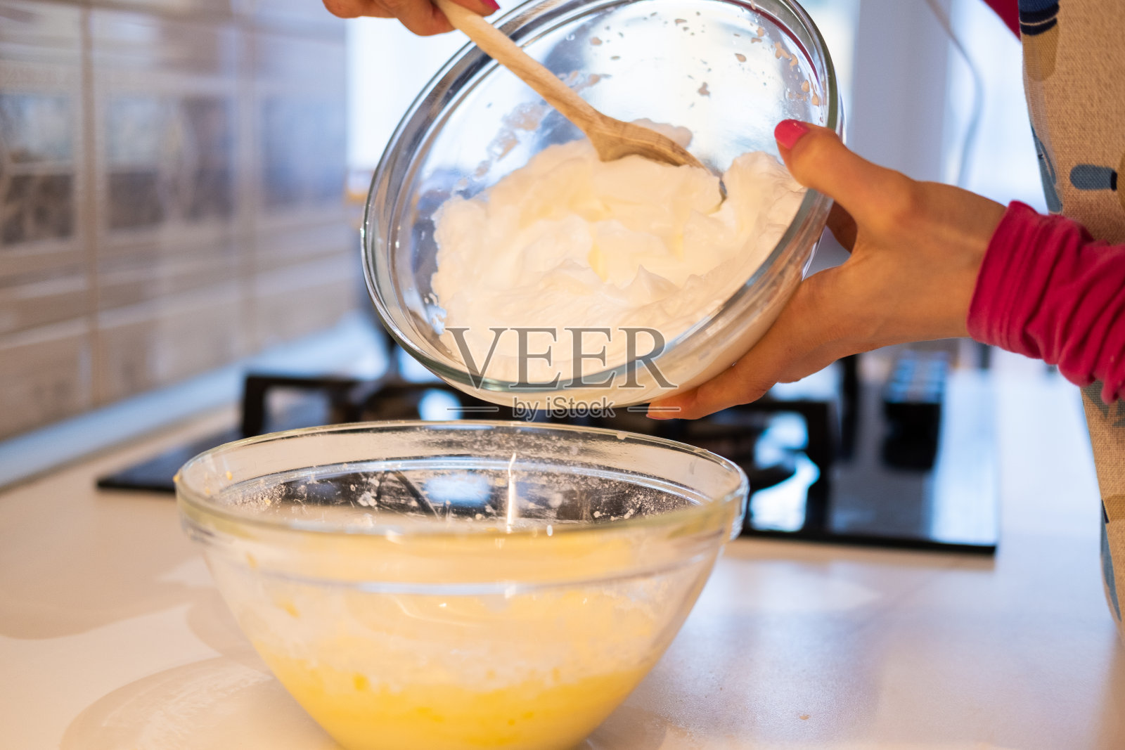 做松饼的女人-把打好的蛋白放进蛋黄里照片摄影图片
