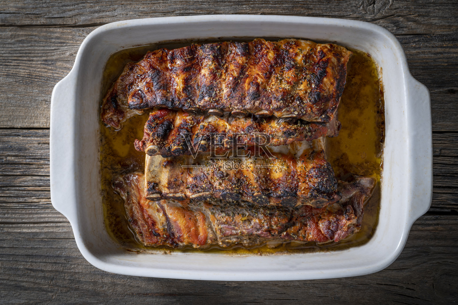 烤排骨与香草和香料放在木头上的托盘照片摄影图片