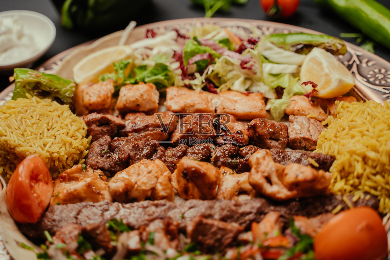 盛在大盘子里的肉丸配米饭和沙拉，装饰上桌。土耳其美食烤肉盘照片摄影图片