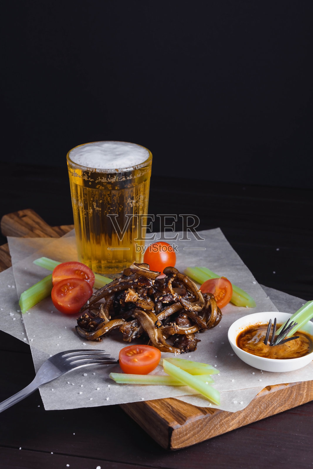 选择的重点是炸猪耳配番茄、芹菜和撒芝麻的酱汁照片摄影图片