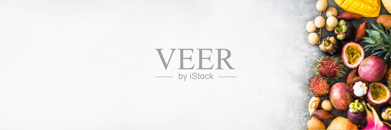 各种新鲜的泰国水果-红毛丹，芒果，山竹，龙眼，木瓜，火龙果，sapodilla，百香果，沙拉克，菠萝在一个木制托盘和灰色的背景。前视图。本空间照片摄影图片