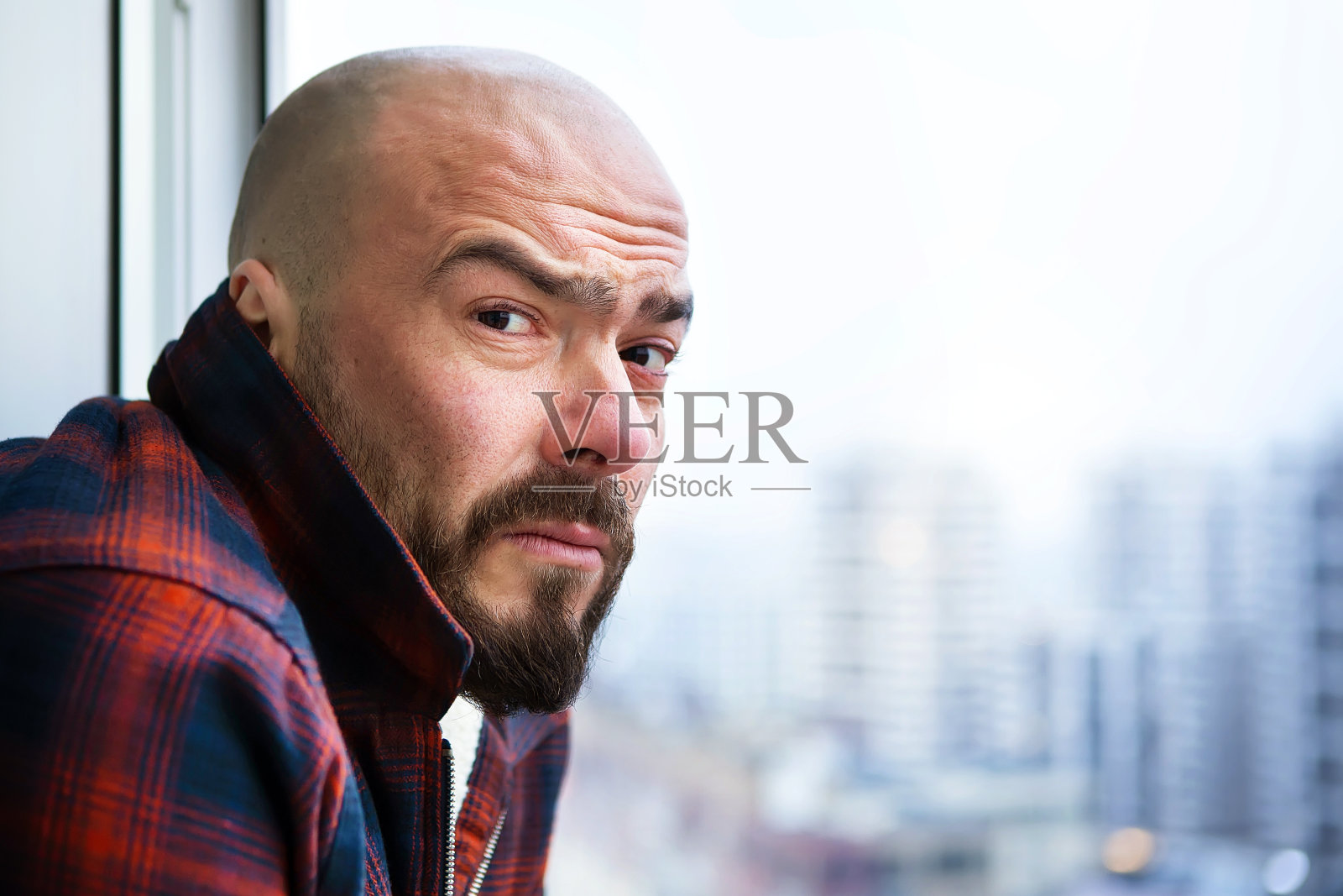 橱窗里一个穿着便服的秃头男人的肖像。照片摄影图片