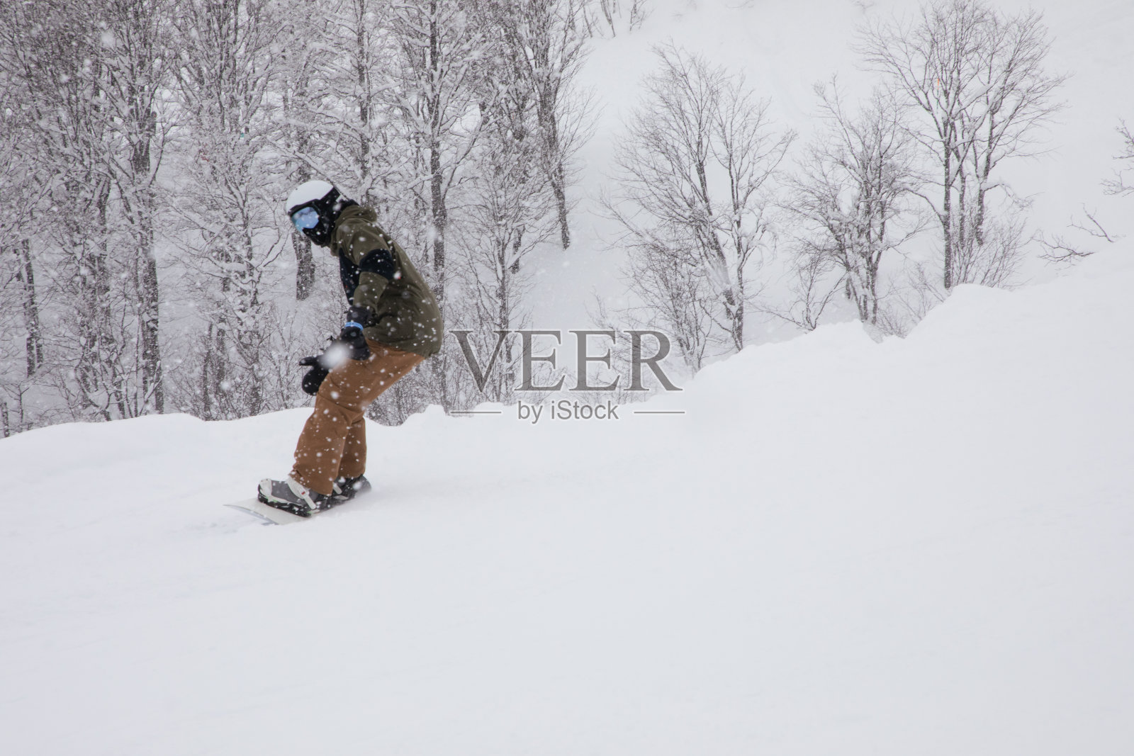 在雪地自由滑雪坡上快速滑行的滑雪者照片摄影图片