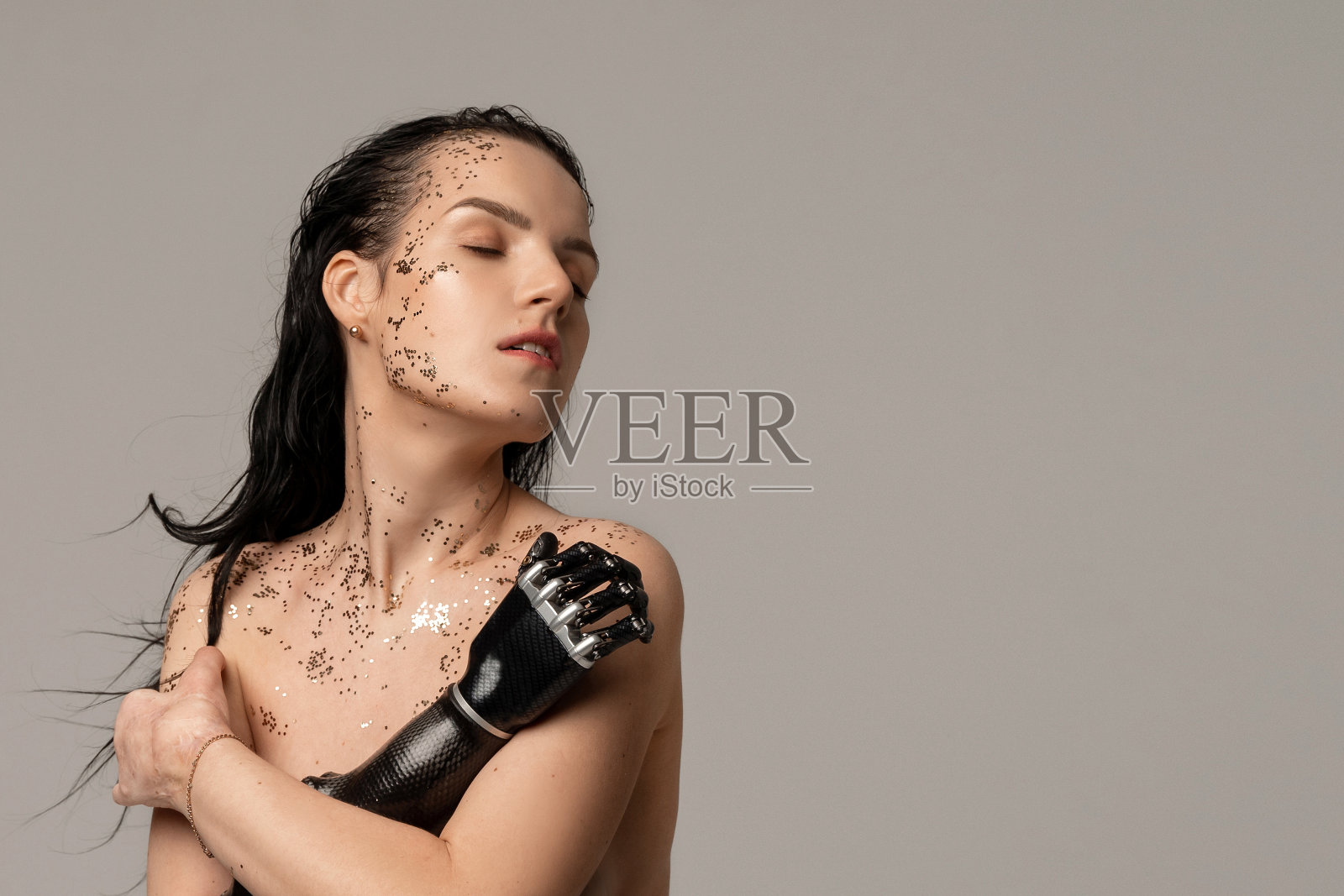 美丽的残疾妇女与义肢，人工手。自然清洁皮肤自然化妆品与闪光新鲜水疗女性美丽的化妆品肖像。照片摄影图片