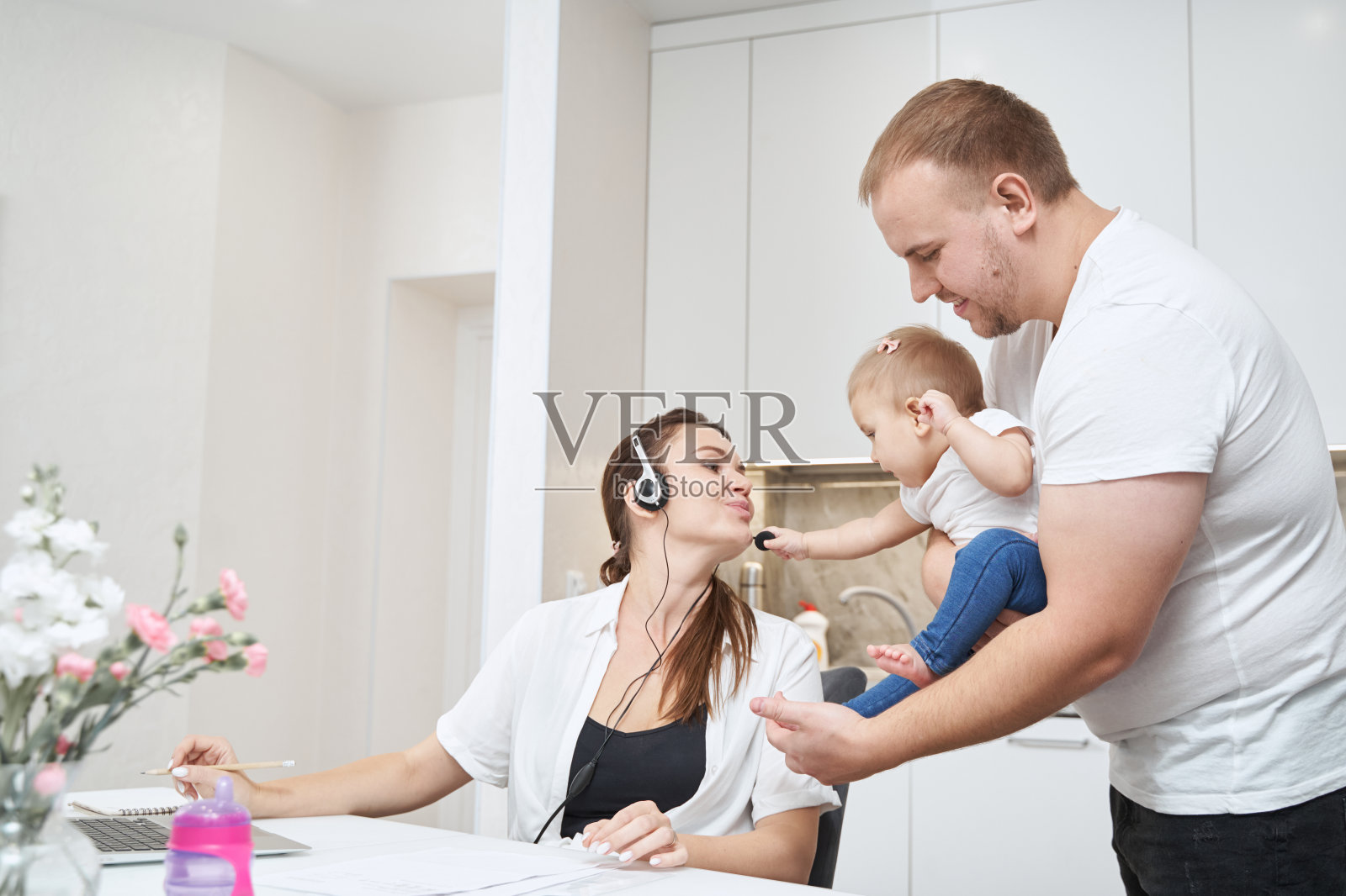 母亲伸出手去亲吻她男人手中的孩子照片摄影图片