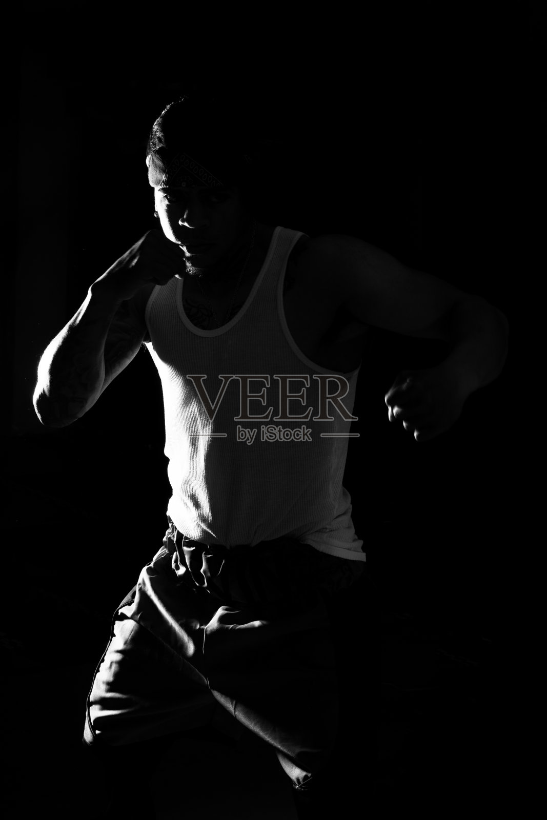 一个年轻人在黑色背景上练习太极拳。照片摄影图片