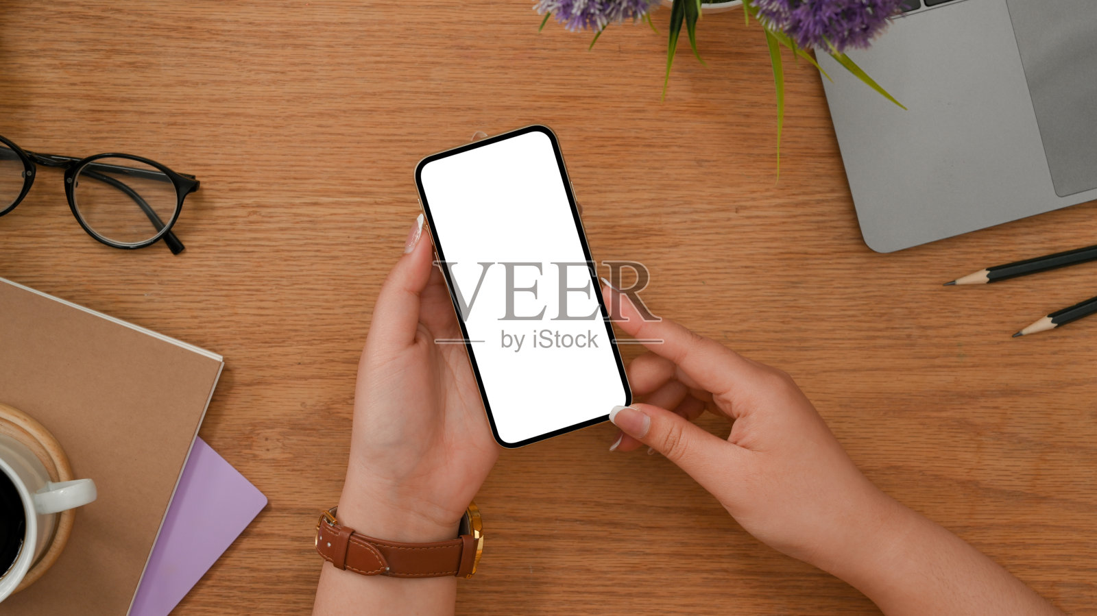 女性在木制办公桌上使用移动应用程序或社交媒体。照片摄影图片