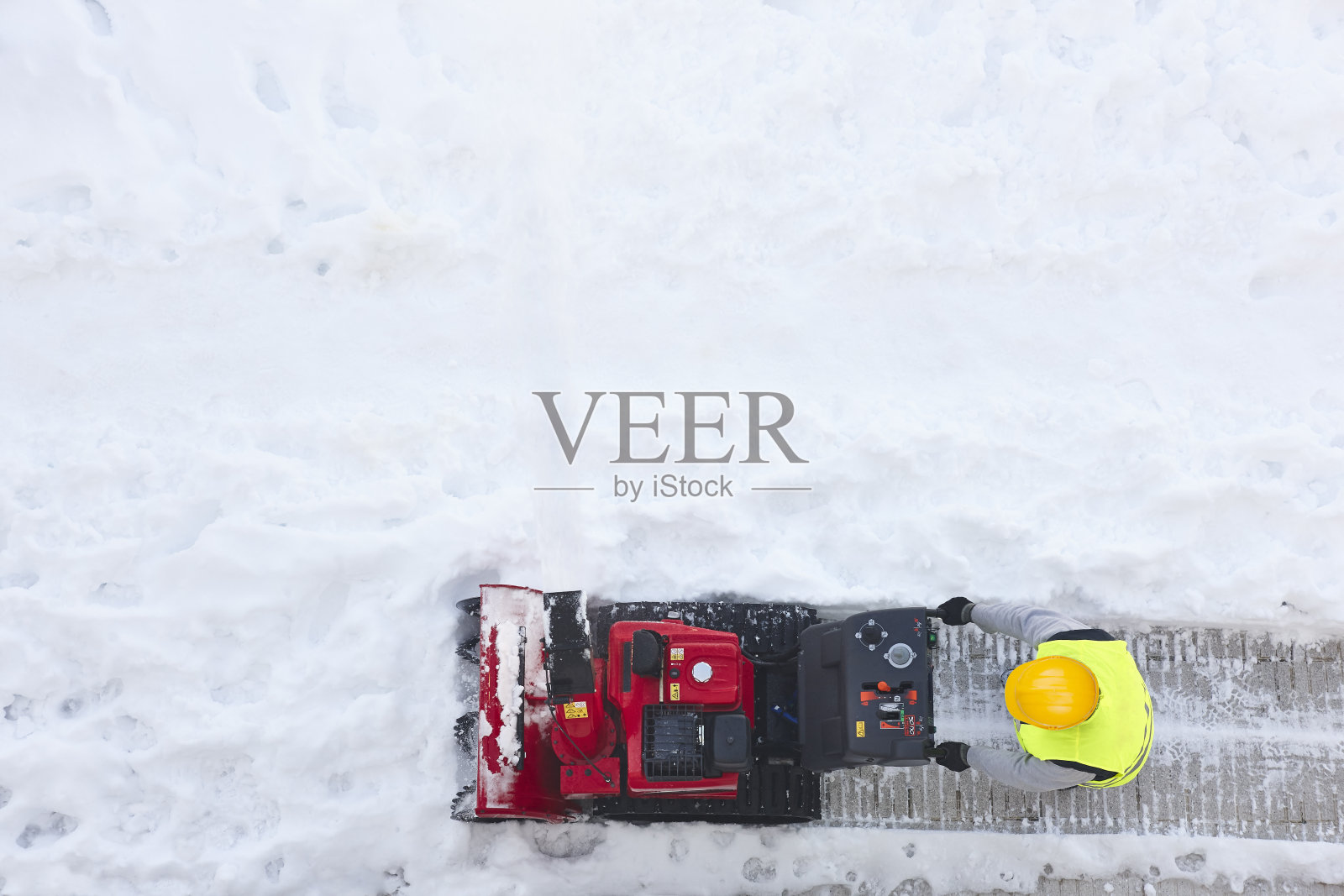 工人在用吹雪机清理人行道上的雪。冬季照片摄影图片