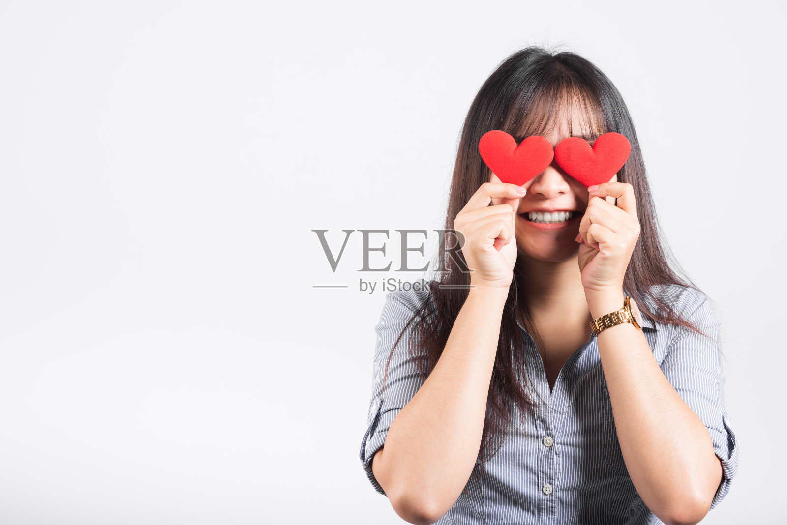 女人站在她的微笑自信开朗开朗的女孩手里拿着两张红心标志卡片闭上眼睛照片摄影图片