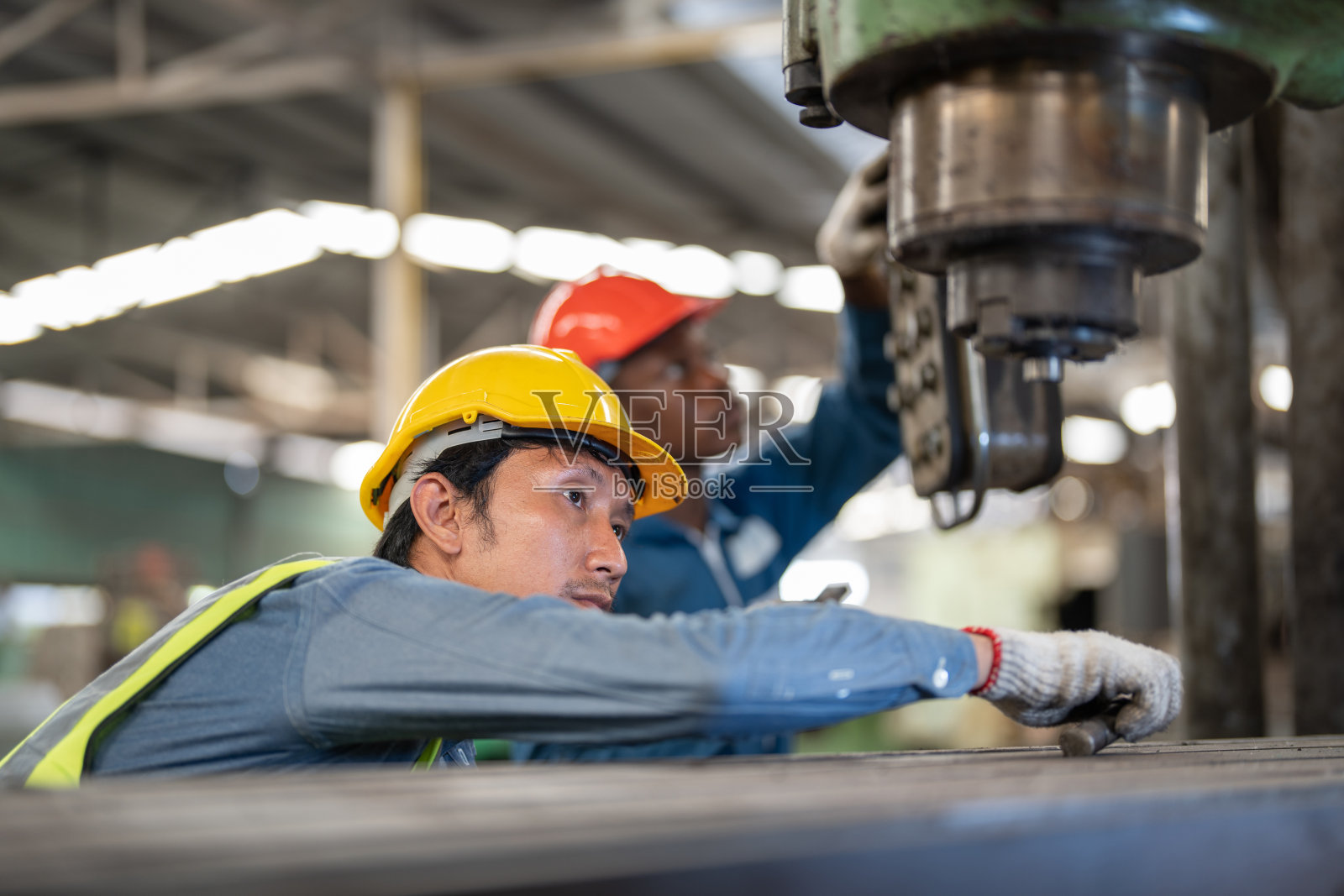 专业的亚洲工人和非洲人的工厂工作在钢铁重型机器。工程训练的员工。在工厂进行安全的操作和控制。照片摄影图片