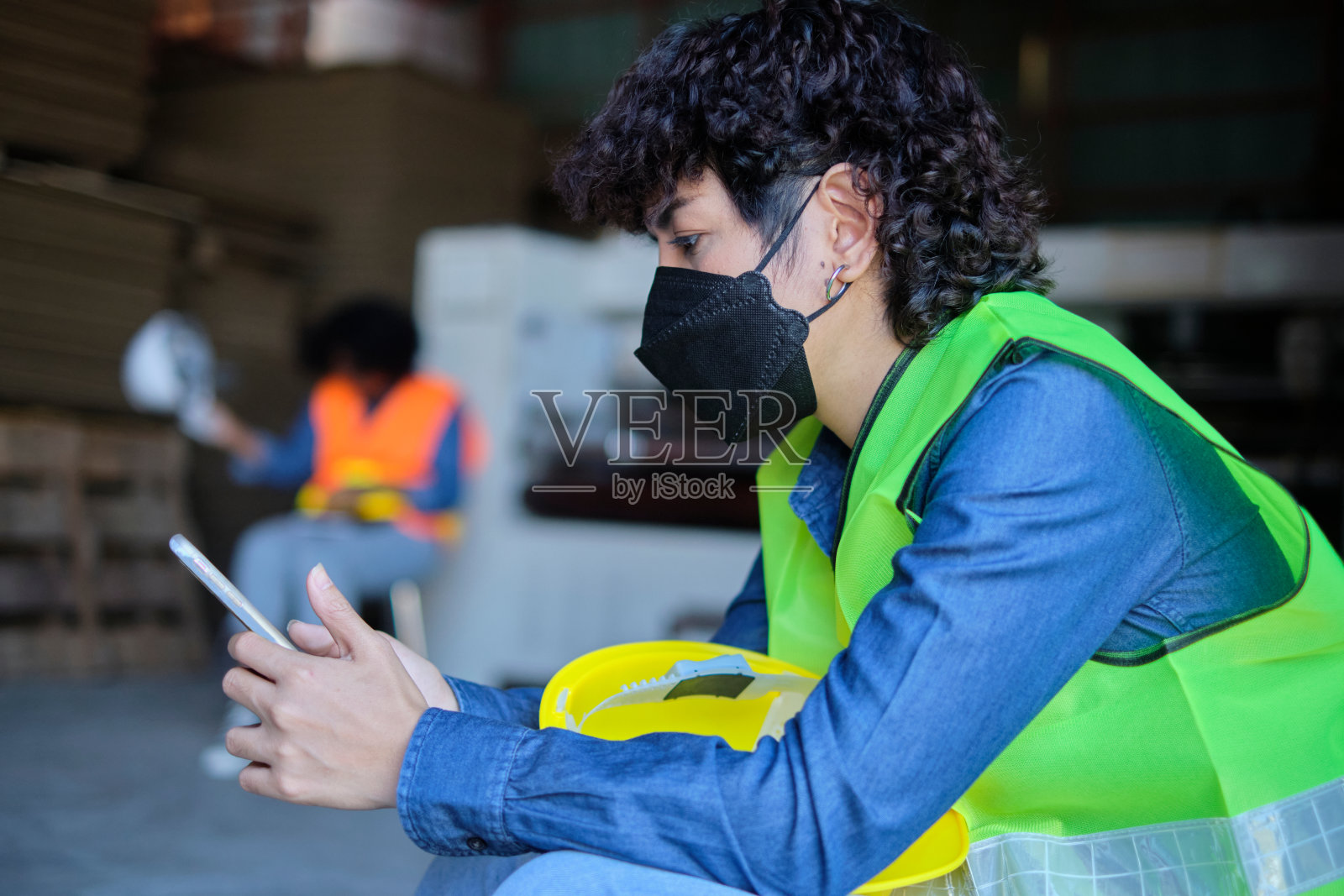 在一家工业工厂里，女工人下班后休息、坐着、聊天。照片摄影图片