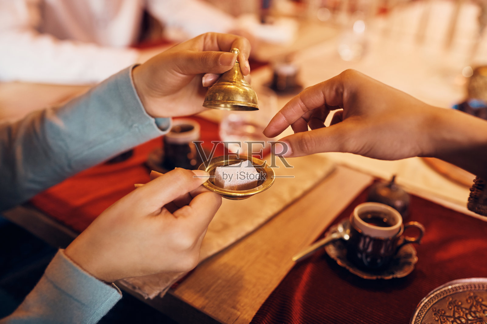 穆斯林妇女在家喝咖啡时吃rahat lokum的特写。照片摄影图片