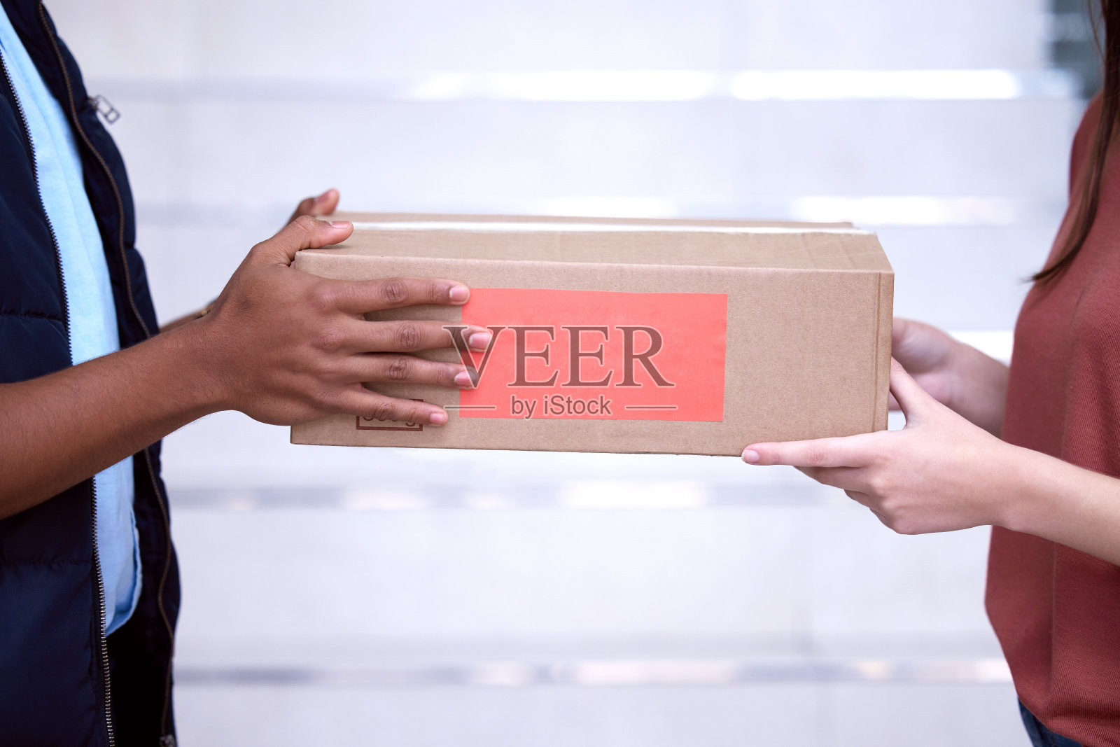 拍摄的是一个女人在接受送货员送的东西照片摄影图片