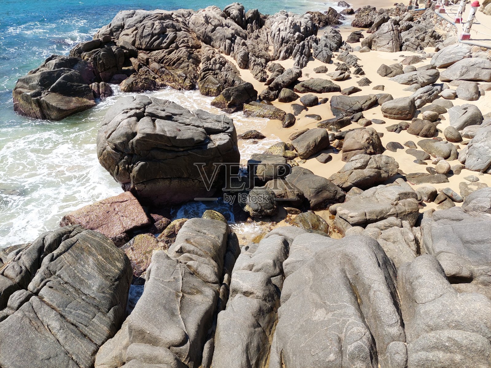 海滩旁的岩层照片摄影图片